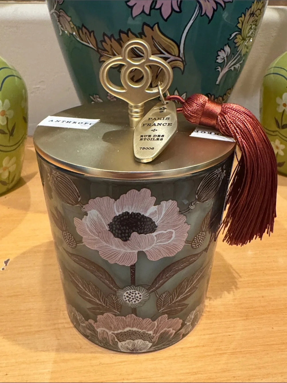 Anthropologie Teakwood & Rose glass candle with brass lid and red tassel